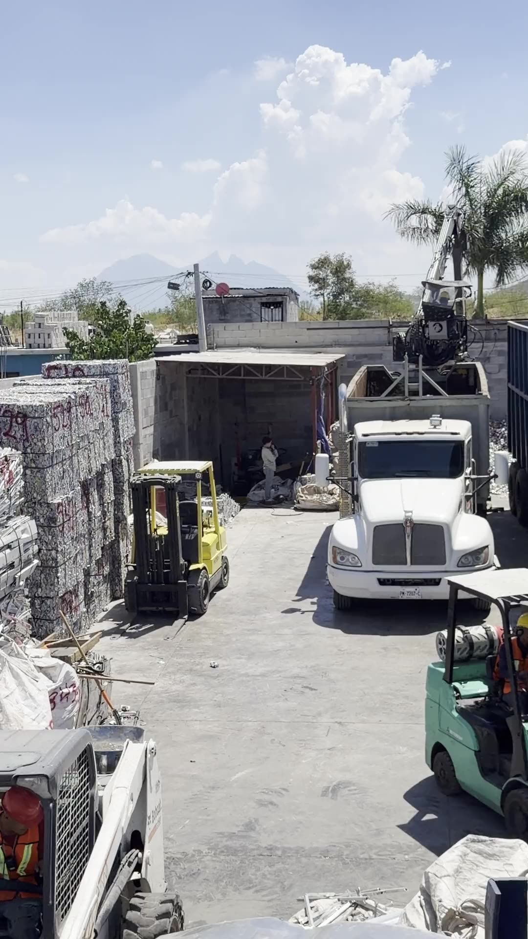 Patio de JC REMMEX con pacas de aluminio, montacargas y tr&aacute;iler cargando